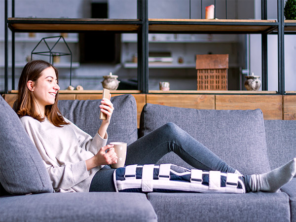 femme avec une attelle à la jambe